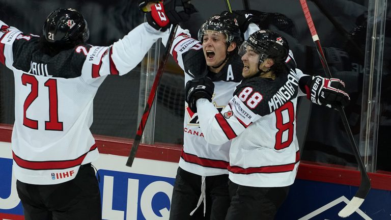 Andrew Mangiapane, Nick Paul and Troy Stecher of Canada celebrate a victory goal during the Ice Hockey World Championship quarterfinal match between Russia and Canada at the Olympic Sports Center in Riga, Latvia, Thursday, June 3, 2021. (Roman Koksarov/AP)