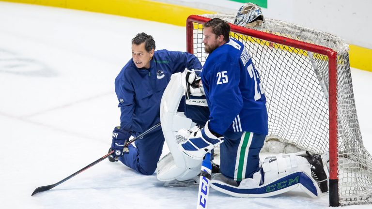 Goaltending coach Ian Clark, left, talks with former Canucks goaltender Jacob Markstrom. (Darryl Dyck/CP)