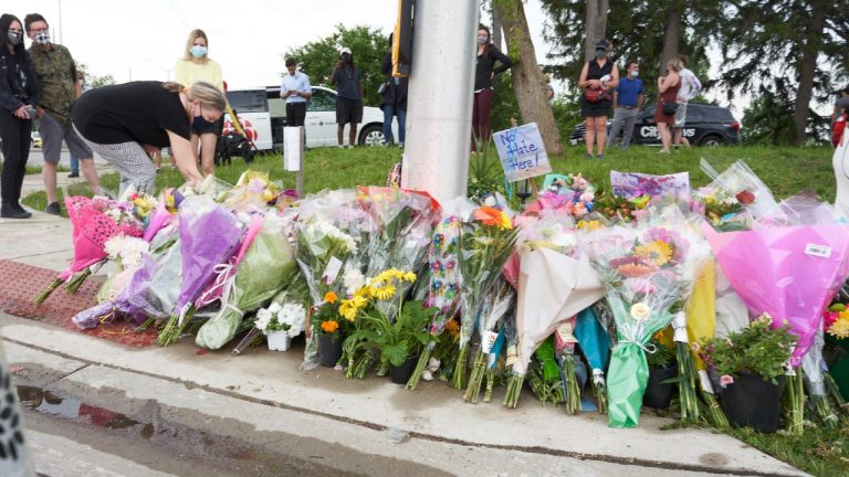 Mourners place flowers at the scene of a hate-motivated vehicle attack in London, Ont. on Tuesday, June 8, 2021. (Geoff Robins/CP) 