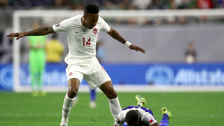 Mark-anthony Kaye #14 of Canada reacts as Wilde-donald Guerrier #10 of Haiti falls on the ball. (Ronald Martinez/Getty Images)