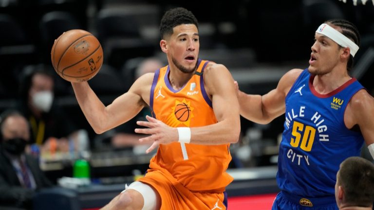 Phoenix Suns guard Devin Booker, left, passes the ball as Denver Nuggets forward Aaron Gordon defends during the first half of Game 3 of an NBA second-round playoff series Friday, June 11, 2021, in Denver. (David Zalubowski/AP) 