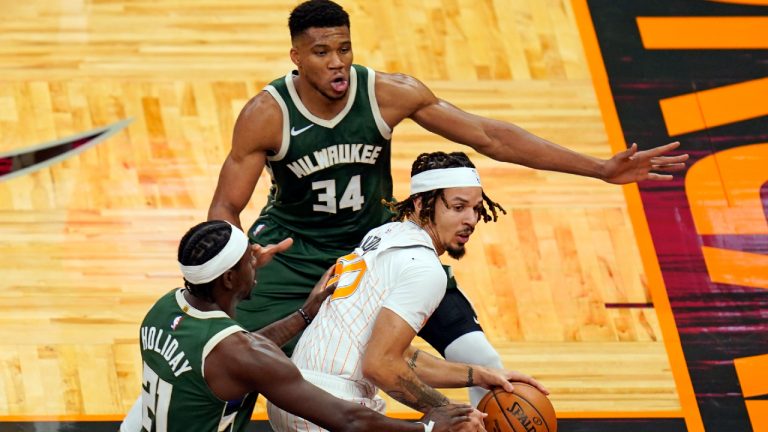 Orlando Magic guard Cole Anthony, center, looks to pass the ball as he is caught between Milwaukee Bucks guard Jrue Holiday, left, and forward Giannis Antetokounmpo (34) during the first half of an NBA basketball game, Monday, Jan. 11, 2021, in Orlando, Fla. (John Raoux/AP) 
