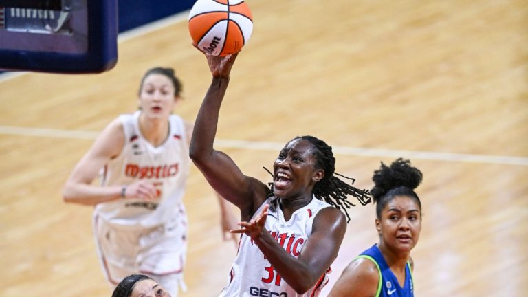 Washington Mystics centre Tina Charles (31) scores and is fouled by Minnesota Lynx forward Natalie Achonwa (11), left, during a WNBA basketball game Tuesday, June 8, 2021, in Washington. (Jonathan Newton/The Washington Post via AP)