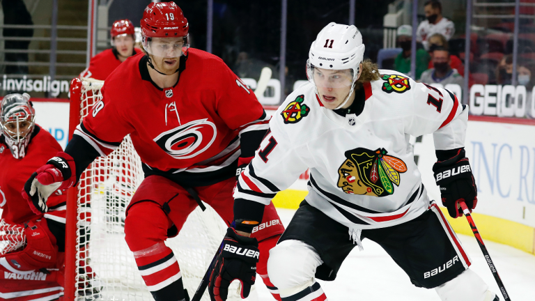 Chicago Blackhawks' Adam Gaudette (11) drives the puck around Carolina Hurricanes' Dougie Hamilton (19) during the first period of an NHL hockey game in Raleigh, N.C., Thursday, May 6, 2021. (Karl B DeBlaker / AP) 