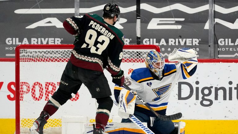 St. Louis Blues goaltender Jordan Binnington, right, is unable to stop a goal by Arizona Coyotes Clayton Keller as Coyotes center Lane Pederson (93) watches during the second period of an NHL hockey game Saturday, April 17, 2021, in Glendale, Ariz. (AP Photo/Ross D. Franklin) 