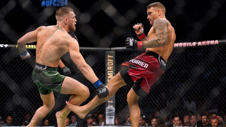 Dustin Poirier, right, kicks Conor McGregor during a UFC 264 lightweight mixed martial arts bout. (John Locher/AP)