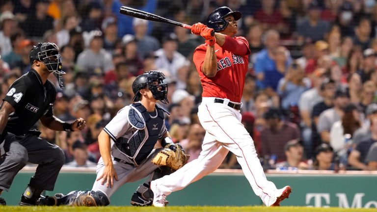 Boston Red Sox star Rafael Devers, right, watches the flight of his three-run home run in front of New York Yankees catcher Gary Sanchez. (Elise Amendola/AP)