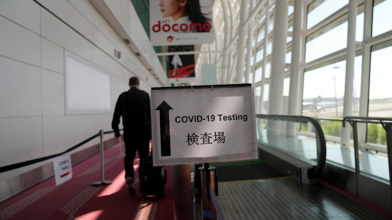 A sign directs passengers arriving in Tokyo, Monday, July 19, 2021, to get their COVID-19 tests before being allowed to enter the country. (Natacha Pisarenko / AP) 