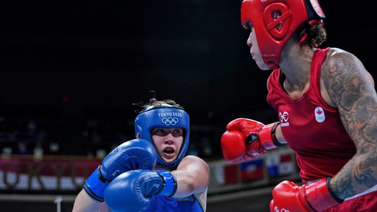 Canada's Tammara Thibeault, in red, and Kazakhstan's Nadezhda Ryabets exchange punches during the women's middleweight 75-kg boxing match at the 2020 Summer Olympics, Wednesday, July 28, 2021, in Tokyo, Japan. (Frank Franklin II/AP, Pool)