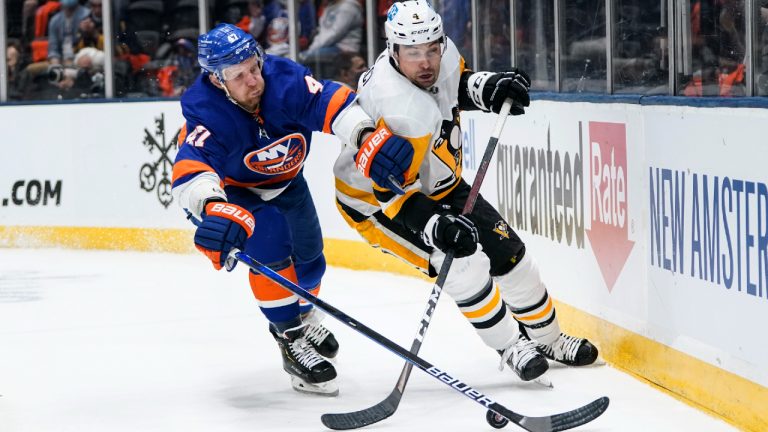 New York Islanders' Leo Komarov (47) fights for control of the puck with Pittsburgh Penguins' Cody Ceci (4) during the second period of Game 3 of an NHL hockey Stanley Cup first-round playoff series Thursday, May 20, 2021, in Uniondale, N.Y. (Frank Franklin II/AP) 
