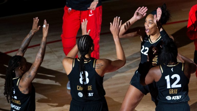 Las Vegas Aces forward A'ja Wilson (22) high-fives guard Chelsea Gray (12), center Liz Cambage (8) and guard Riquna Williams (2) during introductions for the team's WNBA basketball game against the New York Liberty on Tuesday, June 15, 2021, in Las Vegas. (Ellen Schmidt/Las Vegas Review-Journal via AP) 