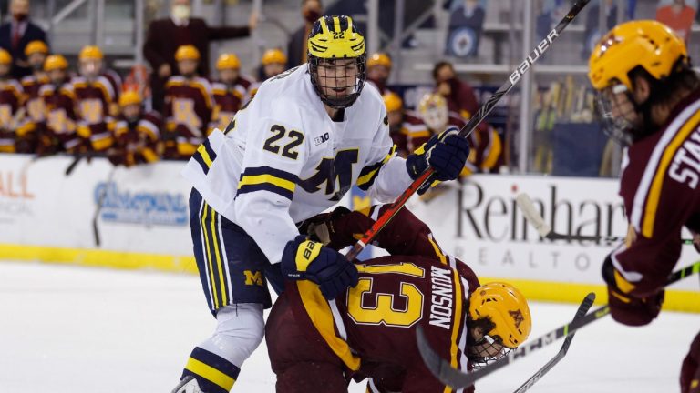 In this Dec. 8, 2020 photo, Michigan's Owen Power (22) watches the puck while working against Minnesota's Cullen Munson (13) during an NCAA hockey game in Ann Arbor, Mich. (Al Goldis/AP) 