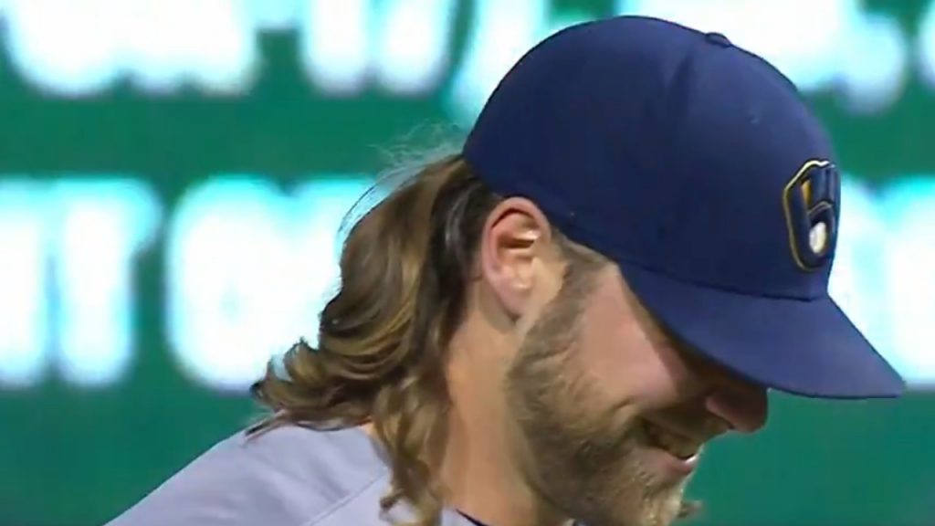 Milwaukee Brewers starter Corbin Burnes adjusts his hair as he