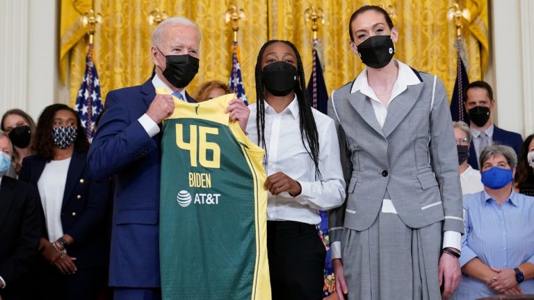 President Joe Biden, left, poses for a photo with the Seattle Storm's Jewell Loyd, centre, and Breanna Stewart, right, during an event in the East Room of the White House. (Susan Walsh/AP)