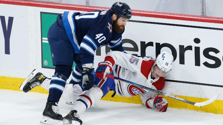 Winnipeg Jets' Jordie Benn (40) and Montreal Canadiens' Jesperi Kotkaniemi (15) get tangled up along the boards during first period NHL playoff action in Winnipeg on Friday, June 4, 2021. (John Woods/CP)