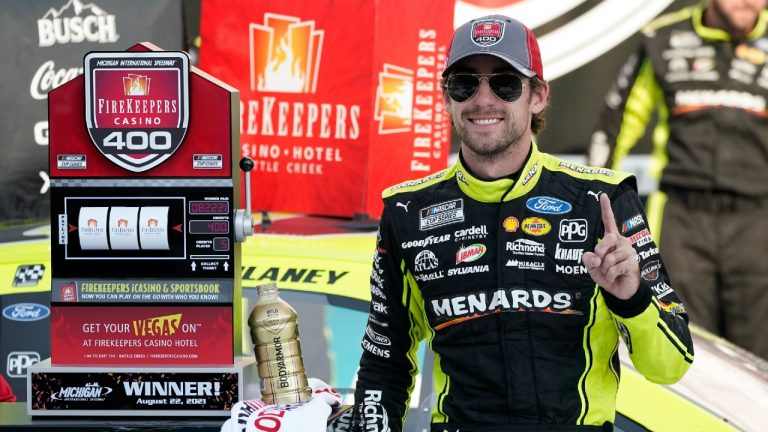 Ryan Blaney stands next to the winner's trophy after the NASCAR Cup Series auto race at Michigan International Speedway, Sunday, Aug. 22, 2021, in Brooklyn, Mich. (Carlos Osorio/AP)