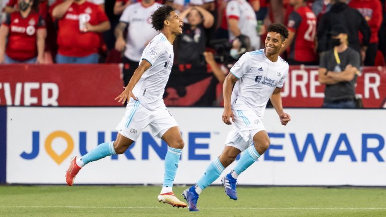 New England Revolution's Tajon Buchanan, left, celebrates his goal with teammate Brandon Bye against Toronto FC during the first half of MLS soccer action in Toronto, Saturday August 14, 2021. (Mark Blinch/CP)