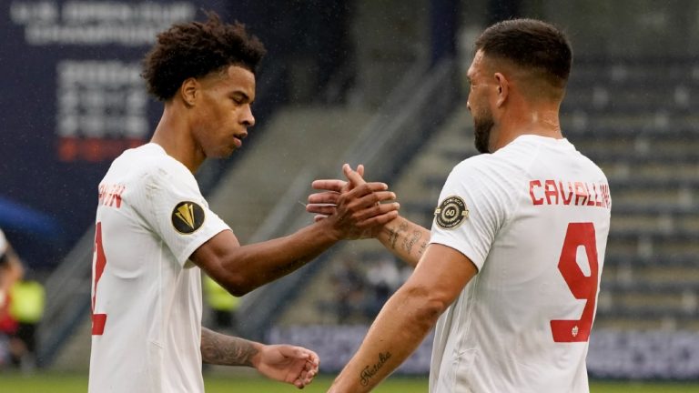 Canada forwards Tajon Buchanan, left, and Lucas Cavallini (9) celebrate after Theodor Corbeanu scored a goal during the second half of a CONCACAF Gold Cup soccer match against Martinique, Sunday, July 11, 2021, in Kansas City, Kan. (Charlie Riedel/AP)