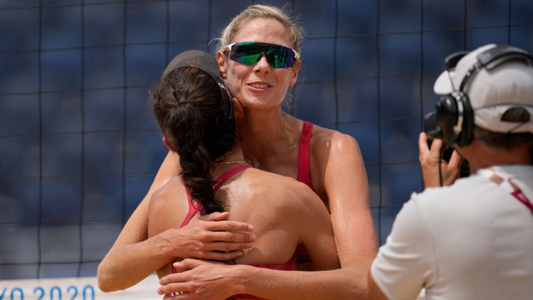 Sarah Pavan, right, of Canada, hugs teammate Melissa Humana-Paredes after winning a women's beach volleyball match against Spain at the 2020 Summer Olympics. (Petros Giannakouris/AP) 