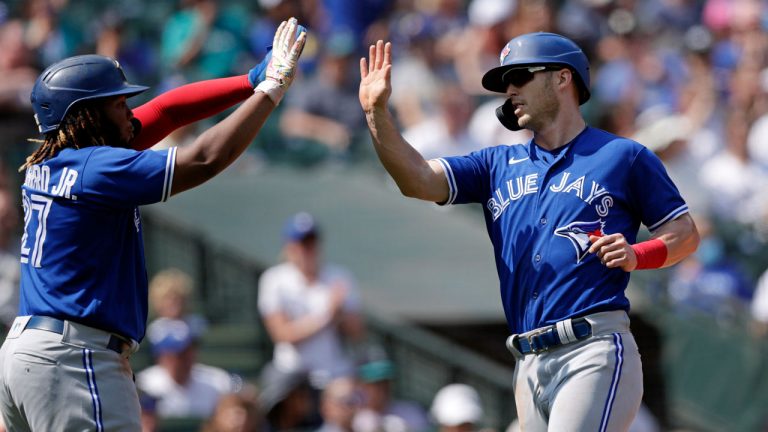 Toronto Blue Jays' Corey Dickerson, right, is greeted at home by Vladimir Guerrero Jr. after both scored by a double by Alejandro Kirk against the Seattle Mariners. (AP)