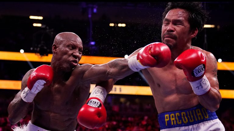 Yordenis Ugas, left, of Cuba, hits Manny Pacquiao, of the Philippines, in a welterweight championship boxing match Saturday, Aug. 21, 2021, in Las Vegas. (John Locher/AP) 
