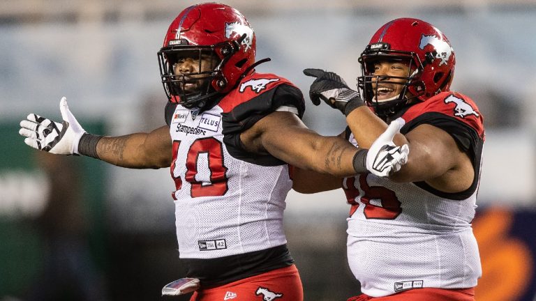 Calgary Stampeders' Shawn Lemon (40) celebrates his tackle on Edmonton Elks quarterback Trevor Harris (7) with Andrew Seinet-Spaulding (96) during second half CFL action in Edmonton, Alta., on Saturday September 11, 2021 (Amber Bracken/CP).