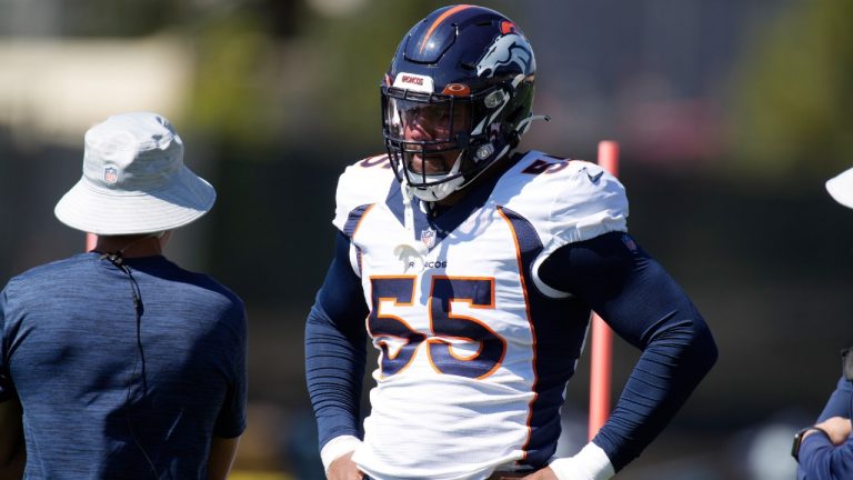 Denver Broncos outside linebacker Bradley Chubb, right, confers with head trainer Vince Garcia as Chubb takes part in drills during a practice. (David Zalubowski/AP)