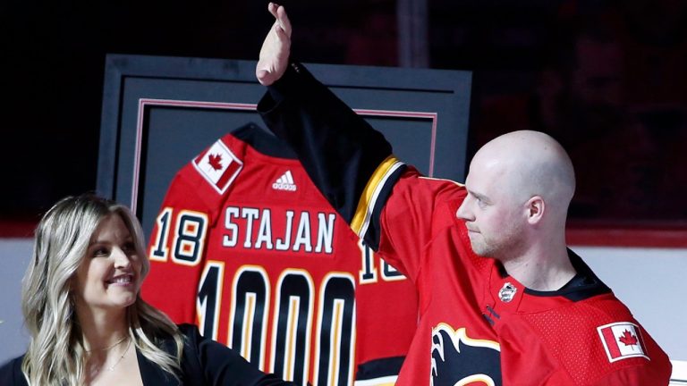 Calgary Flames centre Matt Stajan (18), and his wife Katie wave to the crowd as he's honored for having played 1000 NHL games prior to action against the Columbus Blue Jackets in Calgary, Alta., Thurs., March 29, 2018 (Larry MacDougal/CP).