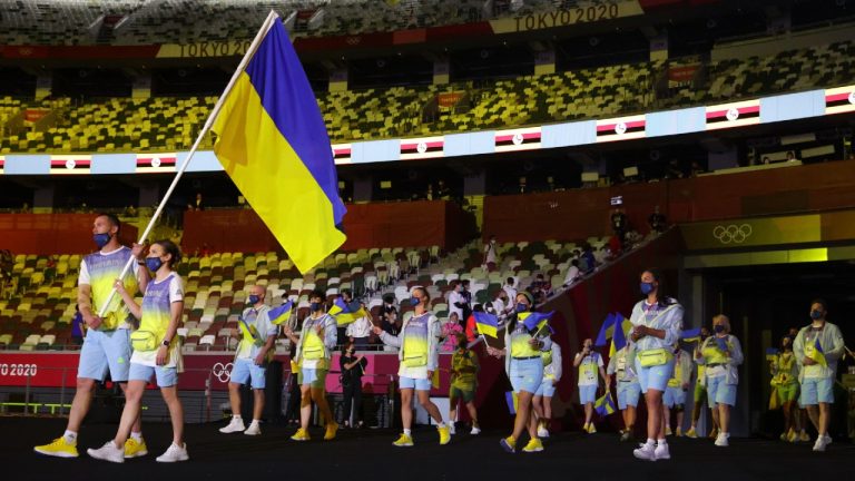 Olena Kostevych and Bogdan Nikishin, of Ukraine, carry their country's flag during the opening ceremony in the Olympic Stadium at the 2020 Summer Olympics, Friday, July 23, 2021, in Tokyo, Japan (Hannah McKay/AP).