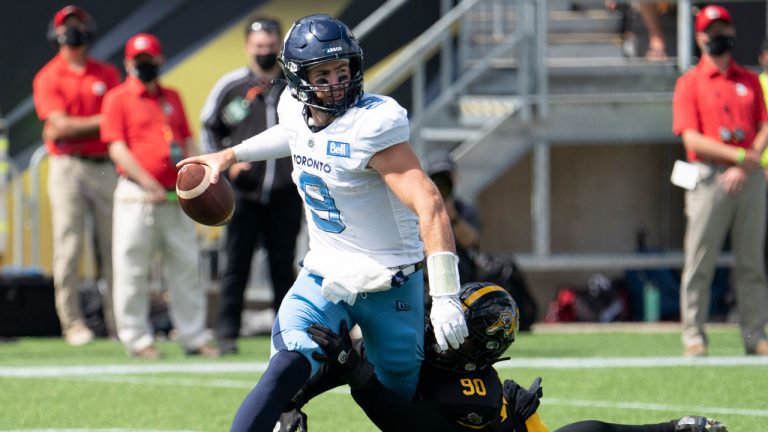 Toronto Argonauts quarterback Nick Arbuckle (9) is sacked by Hamilton Tiger Cats defensive end Mason Bennett (90) during first half CFL football game action. (Peter Power/CP)