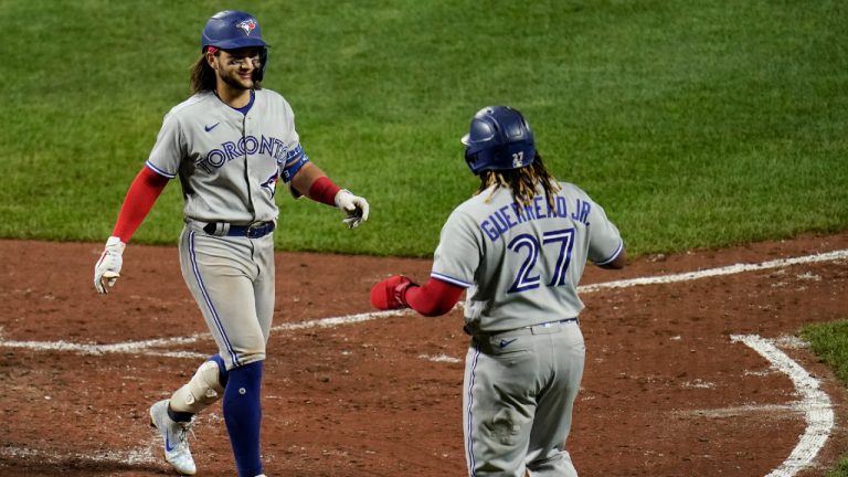 Toronto Blue Jays' Bo Bichette, left, is greeted near home plate by Vladimir Guerrero Jr. after Bichette drove both of them in on a two-run home run off Baltimore Orioles starting pitcher Keegan Akin during the seventh inning of the second game of a baseball doubleheader, Saturday, Sept. 11, 2021, in Baltimore. (Julio Cortez/AP) 
