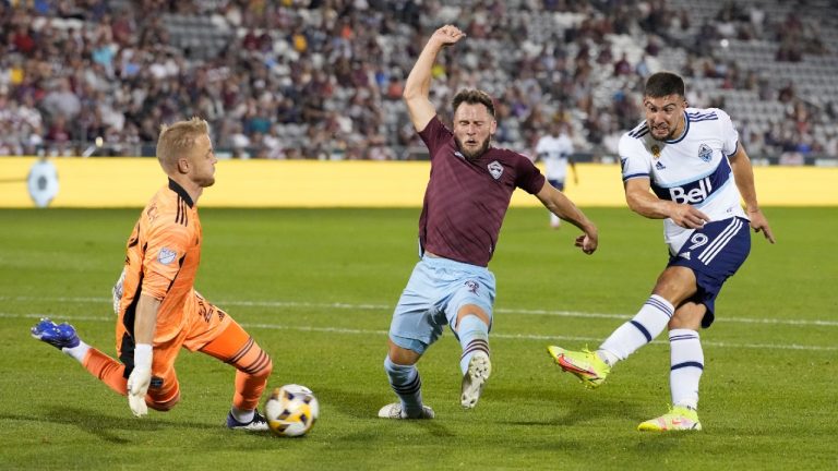 Vancouver Whitecaps forward Lucas Cavallini, right, takes a shot on the net as Colorado Rapids goalkeeper William Yarbrough, left, and defender Keegan Rosenberry cover in the second half of an MLS soccer match Sunday, Sept. 19, 2021, in Commerce City, Colo. The game ended in a 1-1 tie. (David Zalubowski/AP)