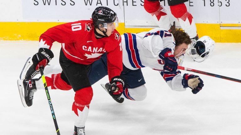 Canada's Dylan Holloway (10) checks United States' Brett Berard (21) during third period IIHF World Junior Hockey Championship gold medal game action. (Jason Franson/CP)