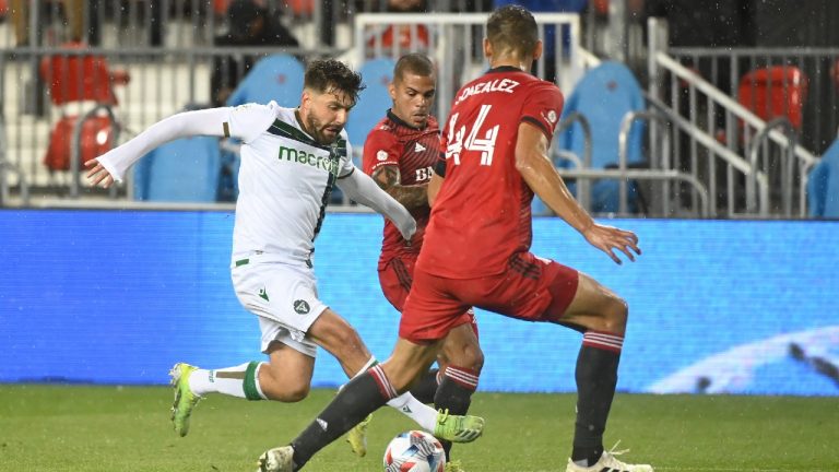 York United FC’s Michael Petrasso, left, works the ball past Toronto FC’s Omar Gonzalez during first half 2021 Canadian Championship quarterfinal soccer action in Toronto on Wednesday, Sept. 22, 2021. (Jon Blacker/CP)