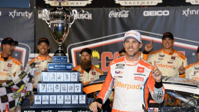 Denny Hamlin stands with the trophy after winning a NASCAR Cup Series auto race Sunday, Sept. 5, 2021, in Darlington, S.C. (John Amis/AP)