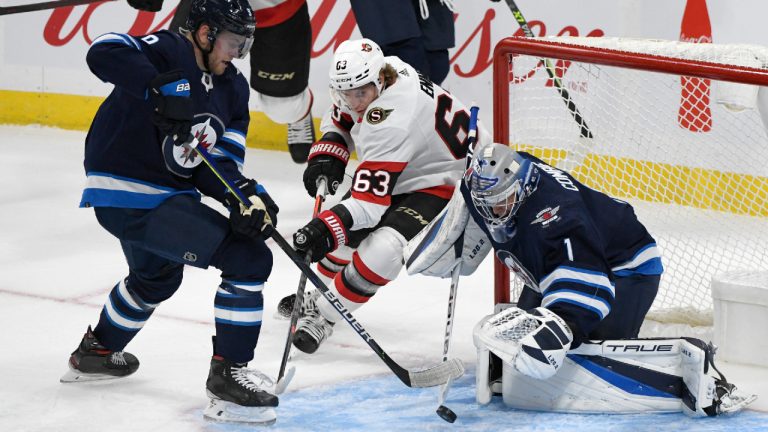 Winnipeg Jets' goaltender Eric Comrie (1) makes a save on Ottawa Senators' Tyler Ennis (63) as Andrew Copp (9) defends during first period NHL preseason action in Winnipeg, Sunday, Sept. 26, 2021. (Fred Greenslade/CP) 
