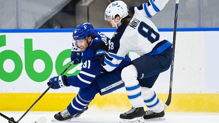 Toronto Maple Leafs centre John Tavares (91) tries to drive past Winnipeg Jets defenceman Sami Niku (8) during third period NHL hockey action in Toronto on Monday, January 18, 2021. (Nathan Denette/CP)