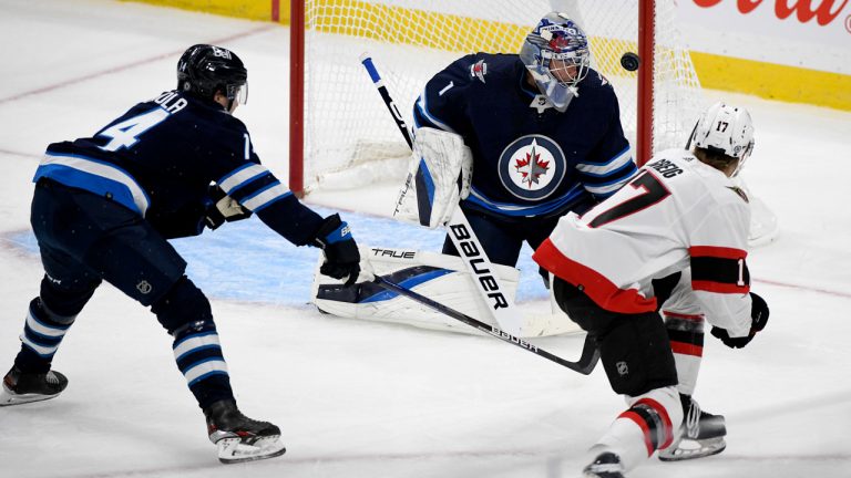 Ottawa Senators' Ridly Greig (17) scores on Winnipeg Jets' goaltender Eric Comrie (1) during first period NHL preseason action. (Fred Greenslade/CP)