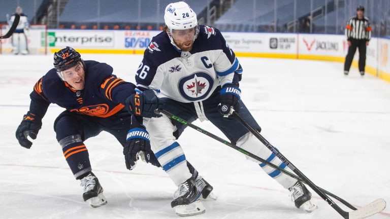 Edmonton Oilers' Tyson Barrie (22) tries to stop Winnipeg Jets' Blake Wheeler (26) during third period NHL Stanley Cup playoff action in Edmonton on Friday, May 21, 2021. (Jason Franson/CP)