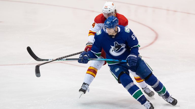 Calgary Flames' Brett Ritchie, back, checks Vancouver Canucks' Tyler Myers during the third period of a pre-season NHL hockey game in Abbotsford, B.C., Monday, Sept. 27, 2021. (Darryl Dyck/CP)