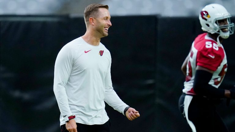 Arizona Cardinals head coach Kliff Kingsbury, left, laughs as he interacts with Cardinals defensive end Chandler Jones (55) during NFL football training camp practice, Monday, Aug. 9, 2021, in Glendale, Ariz (Ross D. Franklin/AP).