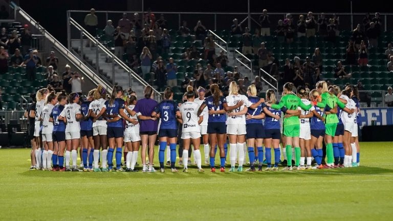 North Carolina Courage and Racing Louisville FC players pause and gather at midfield during the first half of an NWSL soccer match in Cary, N.C., Wednesday, Oct. 6, 2021. (Gerry Broome/AP)