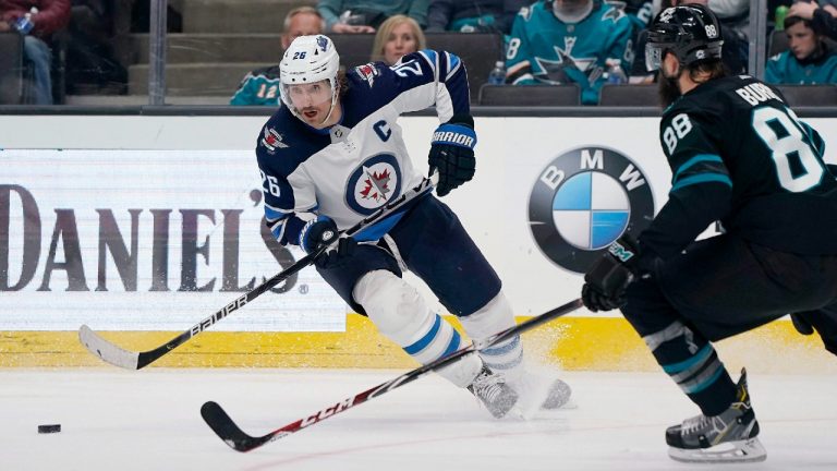 Winnipeg Jets right wing Blake Wheeler (26) moves the puck next to San Jose Sharks defenseman Brent Burns (88) during the second period of an NHL hockey game in San Jose, Calif., Friday, Nov. 1, 2019. (Tony Avelar/AP)