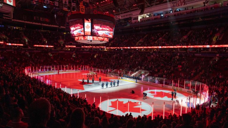 Hockey fans sign along to the Canadian national anthem prior to the NHL pre-season game between the Vancouver Canucks and the Edmonton Oilers in Vancouver, Saturday, October 9, 2021. (Jonathan Hayward/The Canadian Press)
