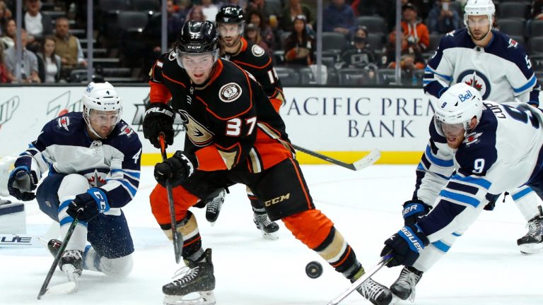 Anaheim Ducks centre Mason McTavish (37) and Winnipeg Jets centre Andrew Copp (9) work for the puck with defenceman Neal Pionk (4) watching during the second period of an NHL hockey game in Anaheim, Calif., Wednesday, Oct. 13, 2021. (Alex Gallardo/AP)