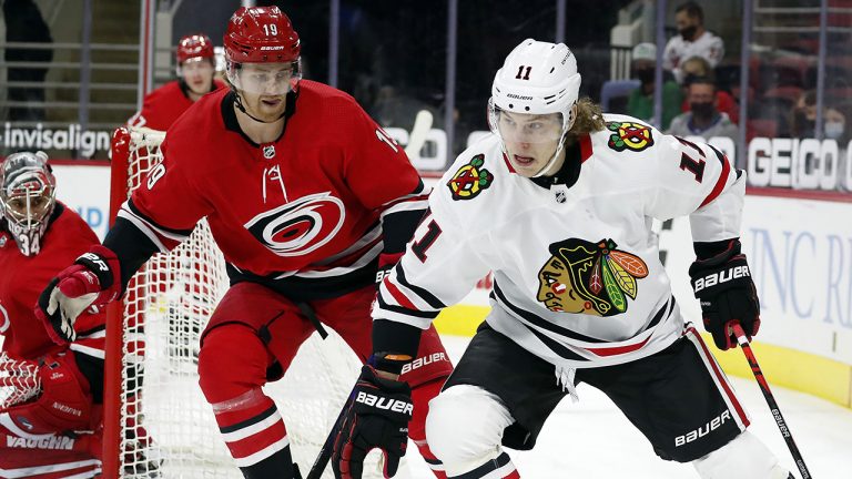 Chicago Blackhawks' Adam Gaudette (11) drives the puck around Carolina Hurricanes' Dougie Hamilton (19) during the first period of an NHL hockey game. (Karl B DeBlaker(AP Photo)