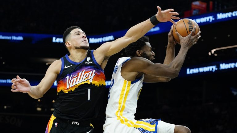 Golden State Warriors forward Andrew Wiggins shoots as Phoenix Suns guard Devin Booker (1) defends. (Matt York/AP)