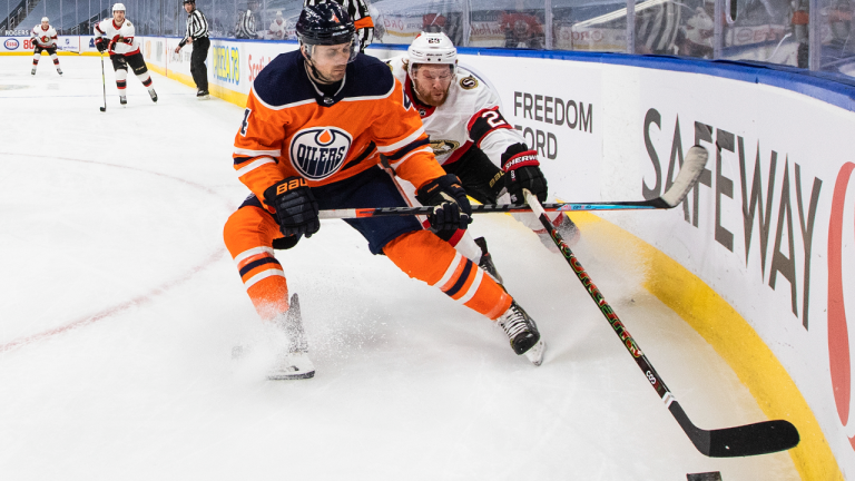 Edmonton Oilers' Kris Russell (4) and Ottawa Senators Connor Brown (28) battle for the puck during first period NHL action in Edmonton on Monday, March 8. (CP/file) 