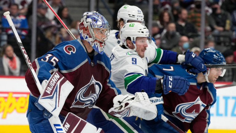 Vancouver Canucks center J.T. Miller, centre, jostles for position with Colorado Avalanche defenceman Devon Toews, right, and goaltender Darcy Kuemper during the second period of an NHL hockey game Thursday, Nov. 11, 2021, in Denver. (AP Photo/David Zalubowski)