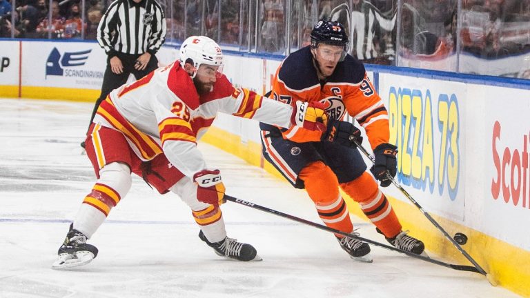 Calgary Flames' Dillon Dube (29) and Edmonton Oilers Connor McDavid (C) (97) battle for the puck during second period NHL pre-season action in Edmonton on Monday, October 4, 2021. (Jason Franson/CP)